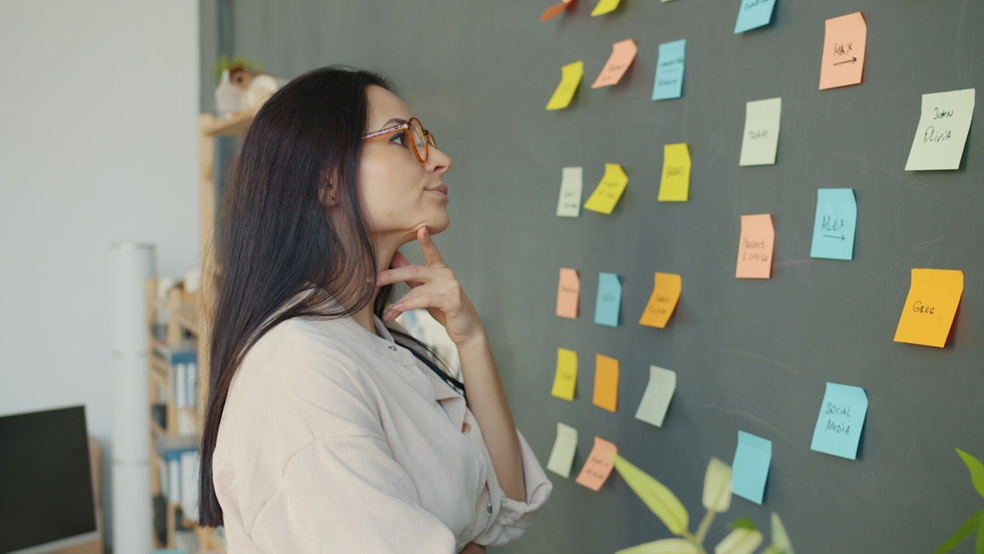 Woman looking at colorful sticky notes on wall
